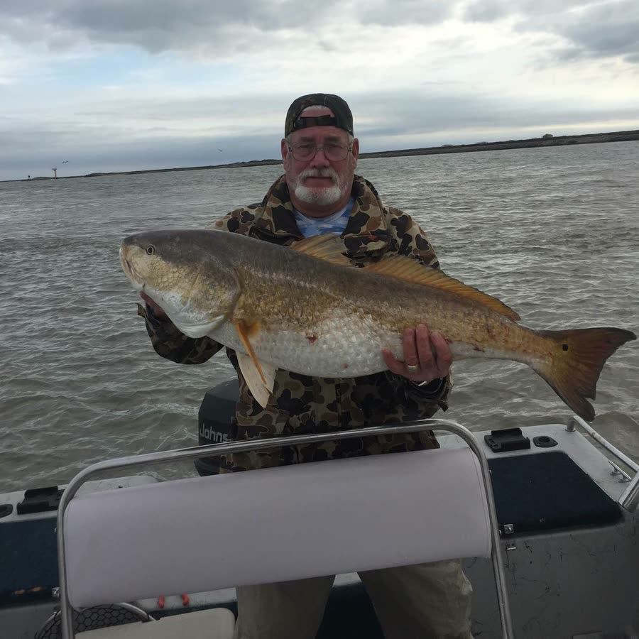 Captain Scott holding a large redfish on his boat near Port O'Connor, Texas